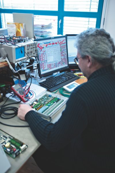 Mann an Schreibtisch mit elektronischen Geräten